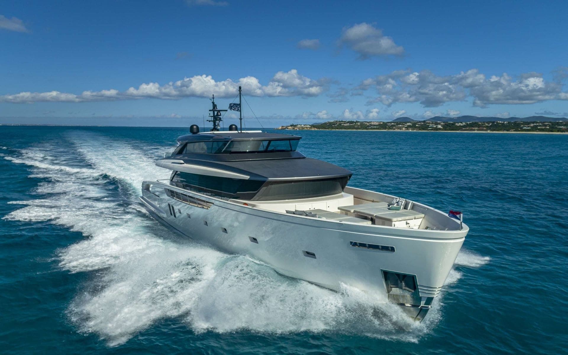 The 112' Sanlorenzo running at speed across blue water, Well Played Editions charter yacht in Miami
