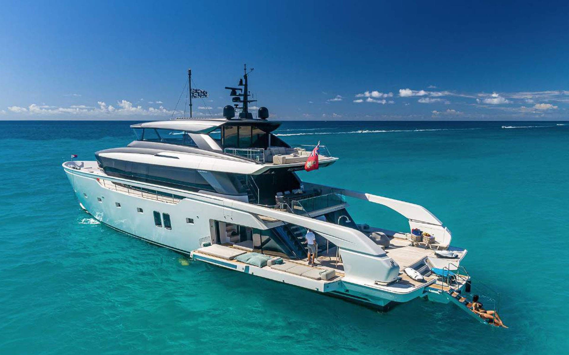 The 112' Sanlorenzo at anchor on turquoise water with the swim platform open