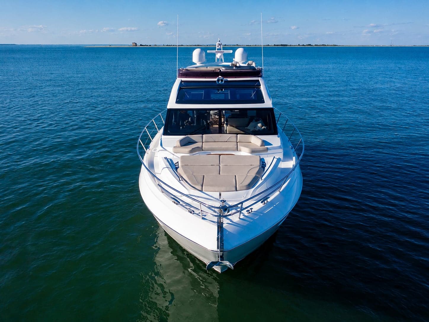The 62' Princess seen from the air at the bow, with her bow sun pad, on calm open water