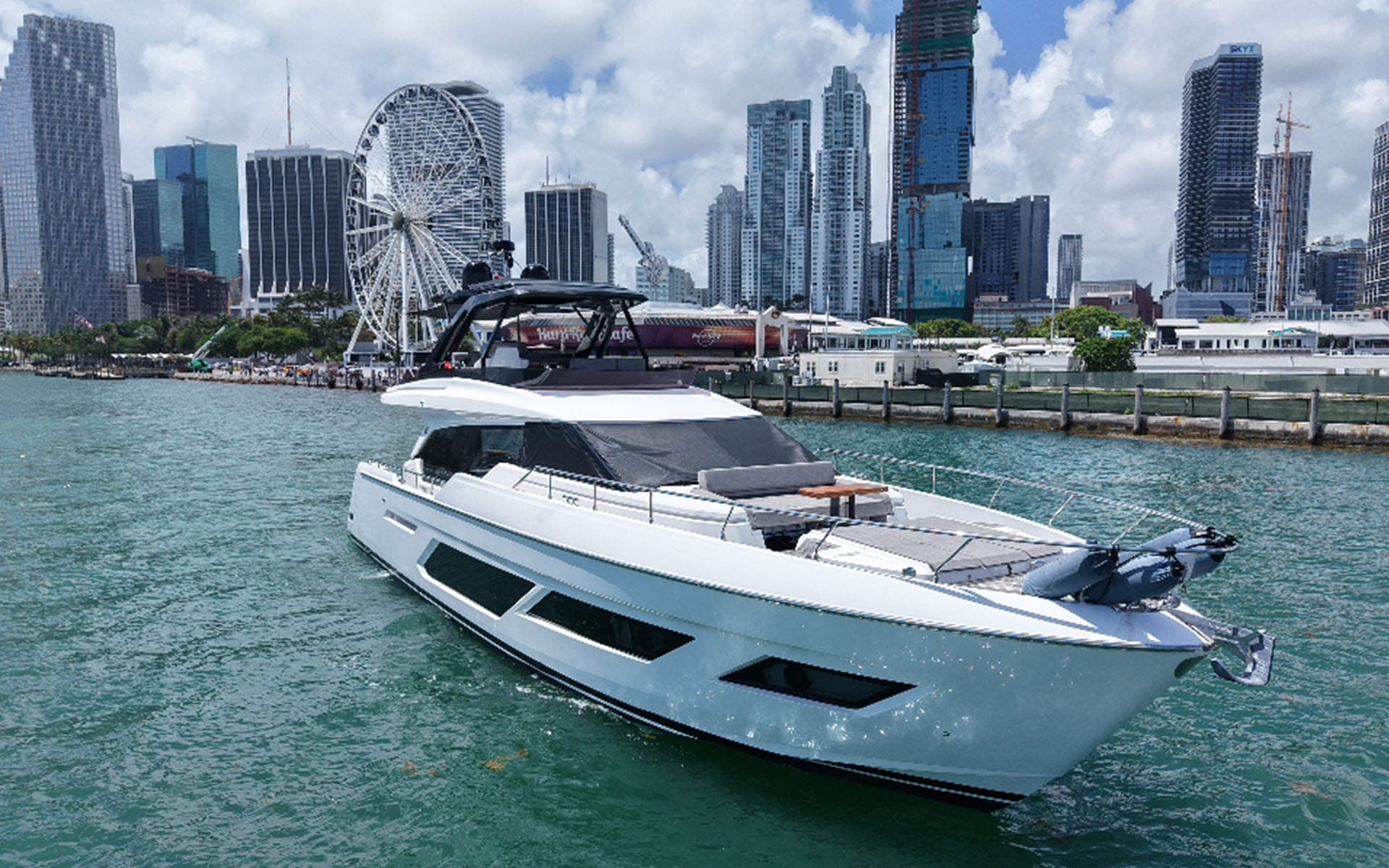 The 80' Ferretti off Bayside with the Miami skyline and Ferris wheel behind