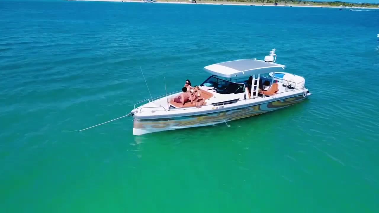 A charter boat at anchor on turquoise water off Shell Key with guests on the bow