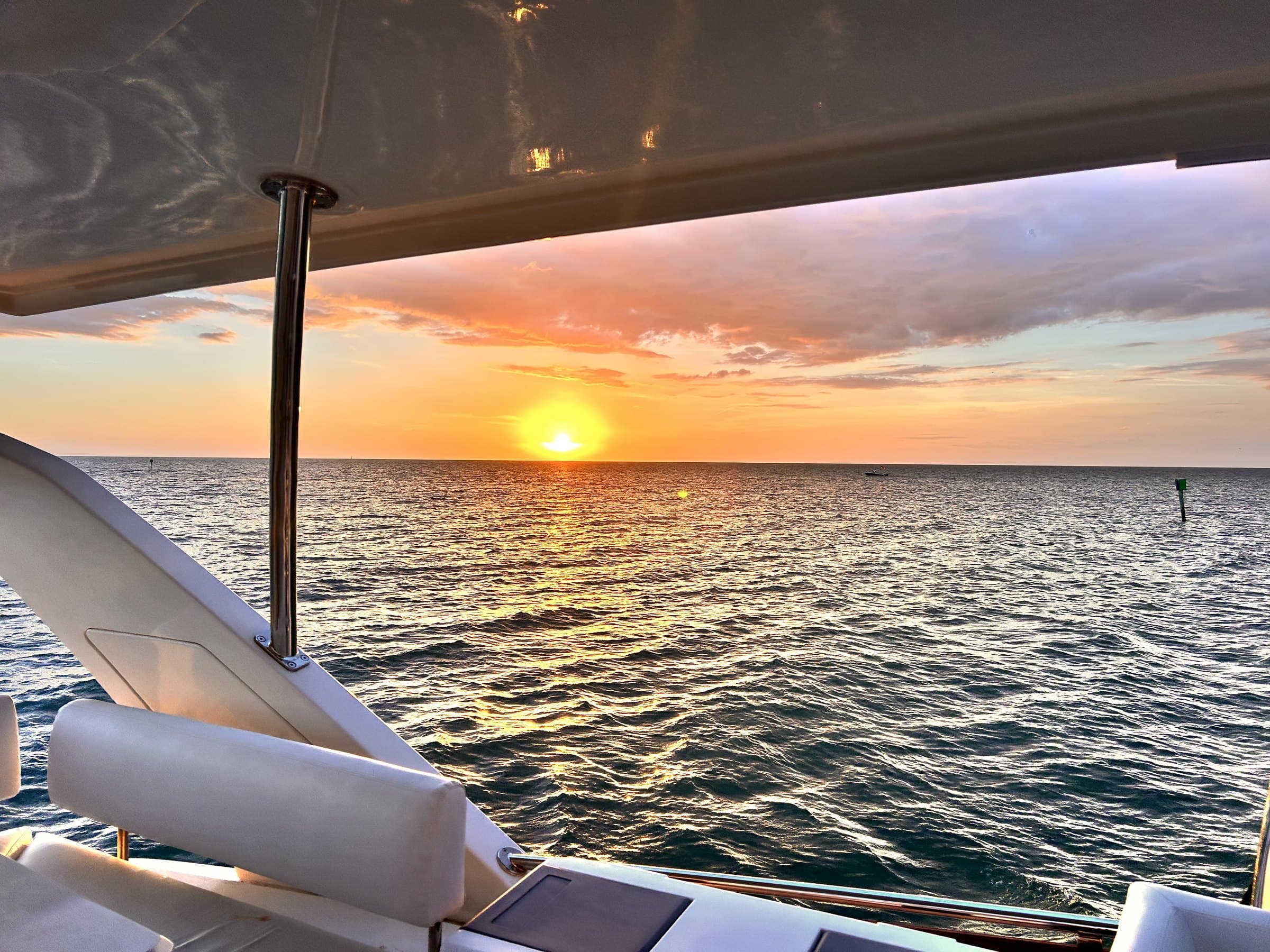 The sunset seen from the yacht's shaded lounge, with the sun low over the water