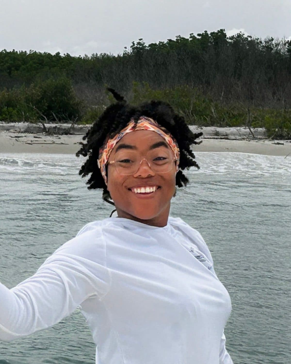 Jordan Braham aboard at a sandbar, smiling, with the beach behind
