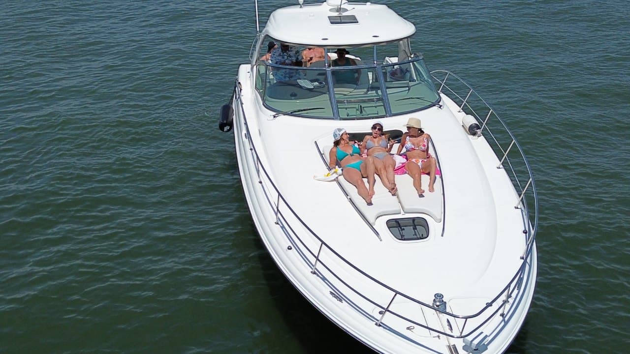 45' Sea Ray from above, guests lounging on the bow sunpad on Tampa Bay