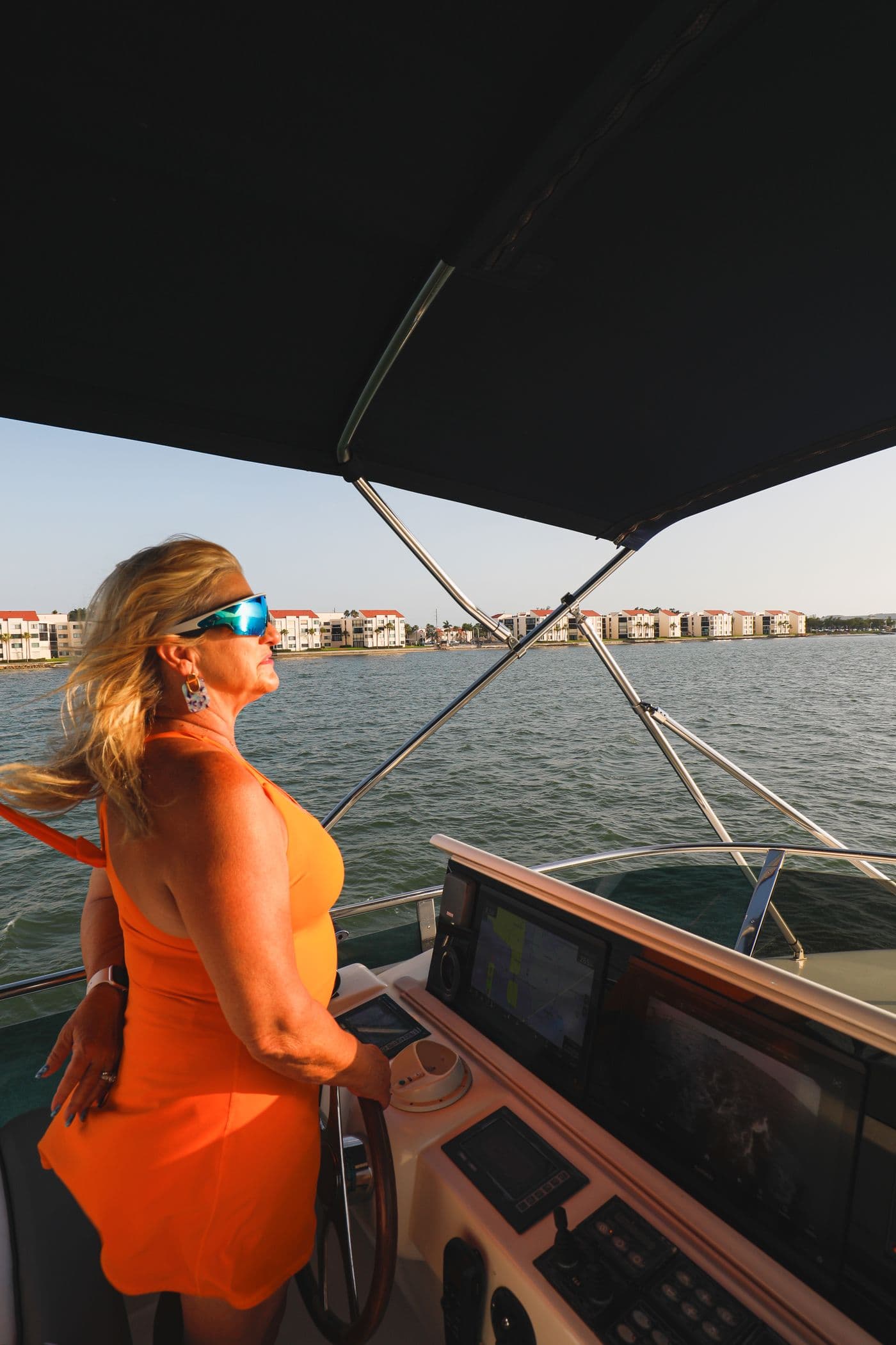 Pamela Cole at the helm of a charter yacht on Tampa Bay at golden hour
