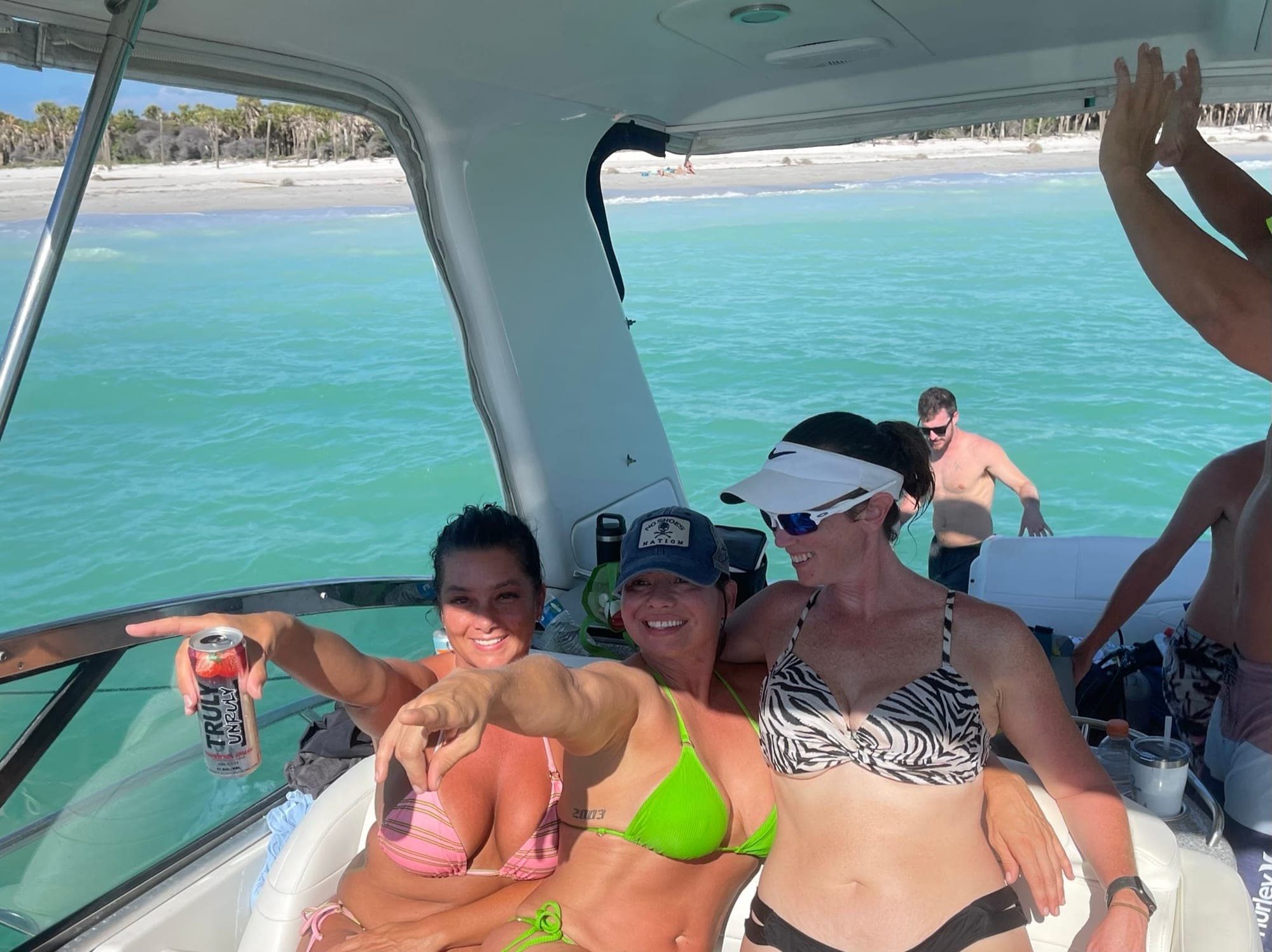 Guests having fun in the shaded cockpit of the 48' Formula off the beach